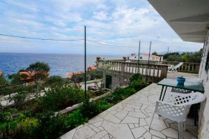 taras ze stołem i krzesłami i widokiem na ocean w obiekcie Apartments by the sea Prigradica, Korcula - 15792 w mieście Blato