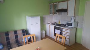 Una pequeña cocina con una mesa y un refrigerador. en Apartments with a parking space Covici, Velebit - 15864, en Otočac 6 fotos más