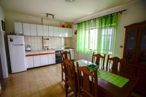 a kitchen with a table and a white refrigerator at Apartments by the sea Prigradica, Korcula - 15792 in Blato