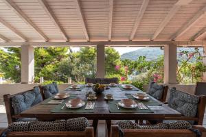 a wooden table and chairs on a patio at Seaside house with a swimming pool Pasadur, Lastovo - 15847 in Lastovo