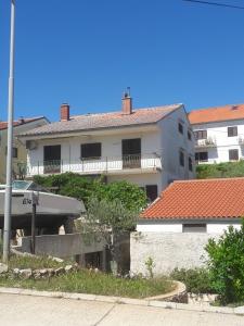 a large white building with a red roof at Apartments with a parking space Mali Losinj (Losinj) - 15858 in Mali Lošinj