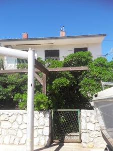 a white house with a gate and a fence at Apartments with a parking space Mali Losinj (Losinj) - 15858 in Mali Lošinj