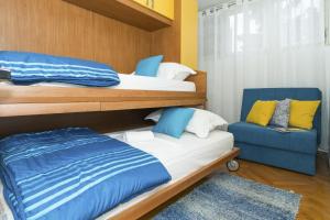 a bedroom with two bunk beds and a blue chair at Apartments with WiFi Split - 15862 in Split