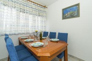 a dining room with a wooden table and blue chairs at Apartments with WiFi Split - 15862 in Split