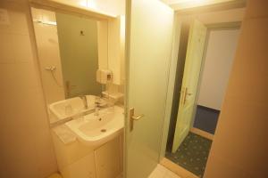 La salle de bains est pourvue d'un lavabo et d'une douche avec un miroir. dans l'établissement Rooms by the sea Zadar - Diklo, Zadar - 16023, à Zadar