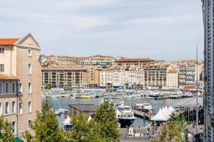 Vue Vieux-Port et Notre Dame, Atypique, Calme, Clim, T2 Chic 48M2,Accès avec code في مارسيليا: ميناء به قوارب في مدينة بها مباني