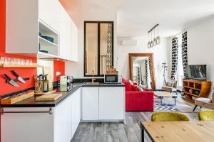 uma cozinha e sala de estar com um sofá vermelho em Vue Vieux-Port et Notre Dame, Atypique, Calme, Clim, T2 Chic 48M2,Accès avec code em Marselha