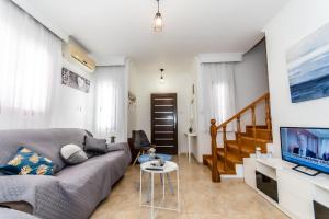 a living room with a couch and a tv at Reel Paradise Villa, Cyprus in Larnaca