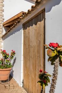 a wooden door on the side of a building with flowers at Reel Paradise Villa, Cyprus in Larnaca