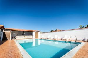a swimming pool with chairs and a house at Reel Paradise Villa, Cyprus in Larnaca
