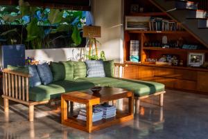 a living room with a green couch and a table at Melali Bingin in Uluwatu