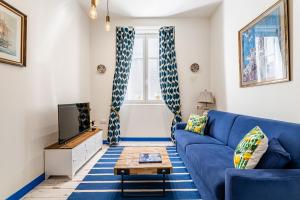 a living room with a blue couch and a tv at Studio Travel 24M2, 120m Vieux-Port ,Clim , Wifi ,Accès avec code, canapé lit in Marseille