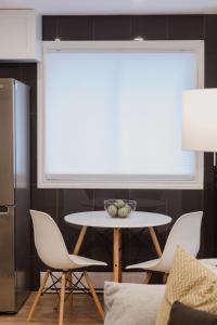 a white table and chairs in a kitchen with a window at Modern, Luxurious Apartment near Downtown Ottawa in Ottawa