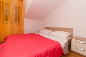 a bedroom with a large bed with a red blanket at Apartment Vodice 16249c in Vodice