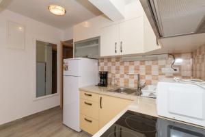 a kitchen with a white refrigerator and a sink at Apartment Vodice 16249c in Vodice