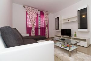- un salon avec un canapé et une télévision dans l'établissement Apartments by the sea Vodice - 16249, à Vodice