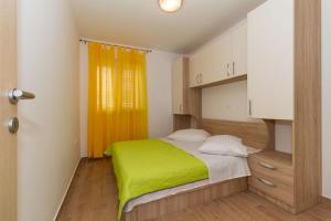 ein Schlafzimmer mit einem Bett mit einer grünen Decke in der Unterkunft Apartment Vodice 16249b in Vodice