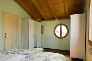 - une chambre avec un lit et une fenêtre ronde dans l'établissement Family friendly house with a swimming pool Ruzici, Opatija - 16202, à Jurdani