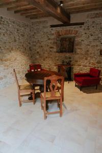 um quarto com uma mesa e cadeiras e uma parede de tijolos em Agriturismo Podere Tovari em Anghiari