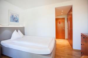 سرير أو أسرّة في غرفة في GUESTHOUSE ZURZACH - Self Check-in