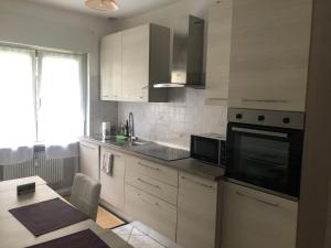 kuchnia z białymi szafkami i czarną kuchenką mikrofalową w obiekcie Casa di Max - private room in apartment with shared bathroom FREE PARKING w mieście Bolzano