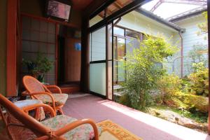 un patio exterior con sillas y una puerta de cristal en ootaryokan en Kuroki