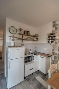 a kitchen with white appliances and a clock on the wall at Drina River Glamping in Loznica