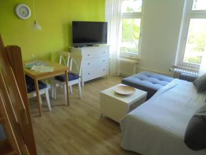 a living room with a bed and a table with a tv at "Ferienhaus Vadersdorf" Wohnung 2 in Vadersdorf