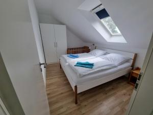 a bedroom with a white bed with a skylight at "Ferienhaus Vadersdorf" Wohnung 2 in Vadersdorf