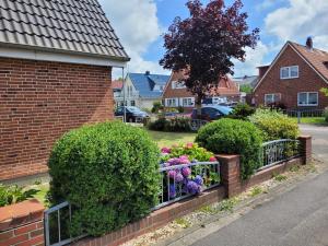 a brick fence with flowers in a residential neighborhood at Neues Schwalbennest 26 Haus in Büsum