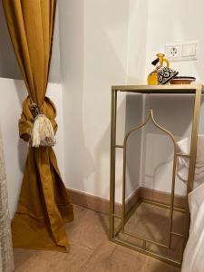 a gold side table with a curtain next to a bed at Sueños de la Alhambra in Granada