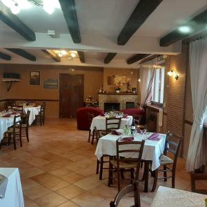 a restaurant with tables and chairs and a fireplace at La Vecchia Fattoria in Pignola