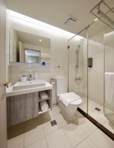 uma casa de banho com um WC, um lavatório e um chuveiro em Hai Fu Hotel & Suites em Jincheng
