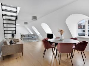 a white living room with a table and chairs at Sanders King in Copenhagen