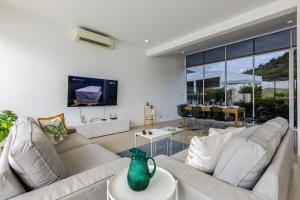 a living room with two white couches and a tv at Modern 4 Bedroom Pool Villa KH-A6 in Khao Tao