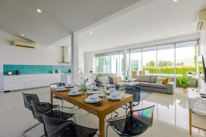 a dining room and living room with a table and chairs at Modern 4 Bedroom Pool Villa KH-A6 in Khao Tao