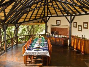 a dining room with a long table in a building at Lianshulu BUSH Lodge in Kongola