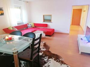 NiederdorfeldenにあるCozy Apartment near Frankfurtの赤いソファとテーブルのあるリビングルーム