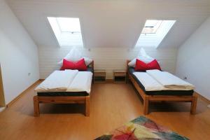 two beds in a room with two windows at Cozy Apartment near Frankfurt in Niederdorfelden