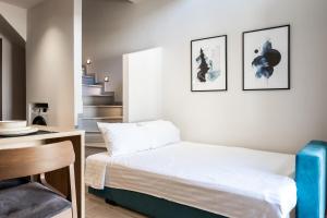 1 dormitorio con cama, escritorio y escalera en Empress Luxury Residences, en Volos