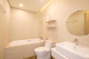 een badkamer met een toilet, een bad en een wastafel bij FLC Sea Tower Quy Nhơn- Đông Ngô House in Quy Nhon