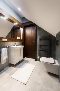 een badkamer met een wastafel, een bad en een toilet bij Janasiówka in Kamesznica