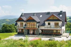 a house with a black roof on top of a hill at Janasiówka in Kamesznica