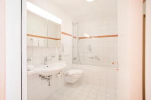 GUESTHOUSE ZURZACH - Self Check-in في باد زورزاخ: حمام أبيض مع حوض ومرحاض