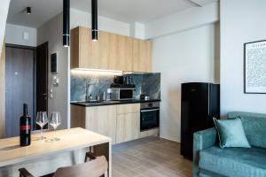 a living room with a couch and a table with wine glasses at Empress Luxury Residences in Volos