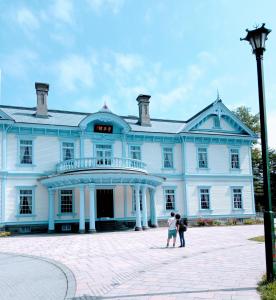 two people standing in front of a large blue building at aup178 in Sapporo