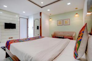 a bedroom with a large bed and a television at FabHotel Vardhan House in Pune