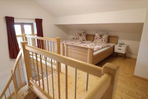 a small bedroom with a bed and a staircase at Grüntenblick in Weitnau