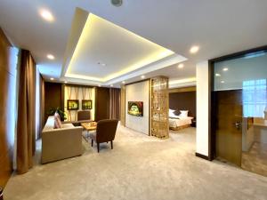uma sala de estar com um sofá e um quarto com uma cama em Muong Thanh Luxury Nhat Le Hotel em Dong Hoi