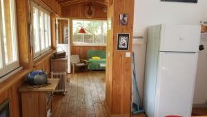 uma cozinha com um frigorífico e uma sala de estar em les cabanes em Lège-Cap-Ferret